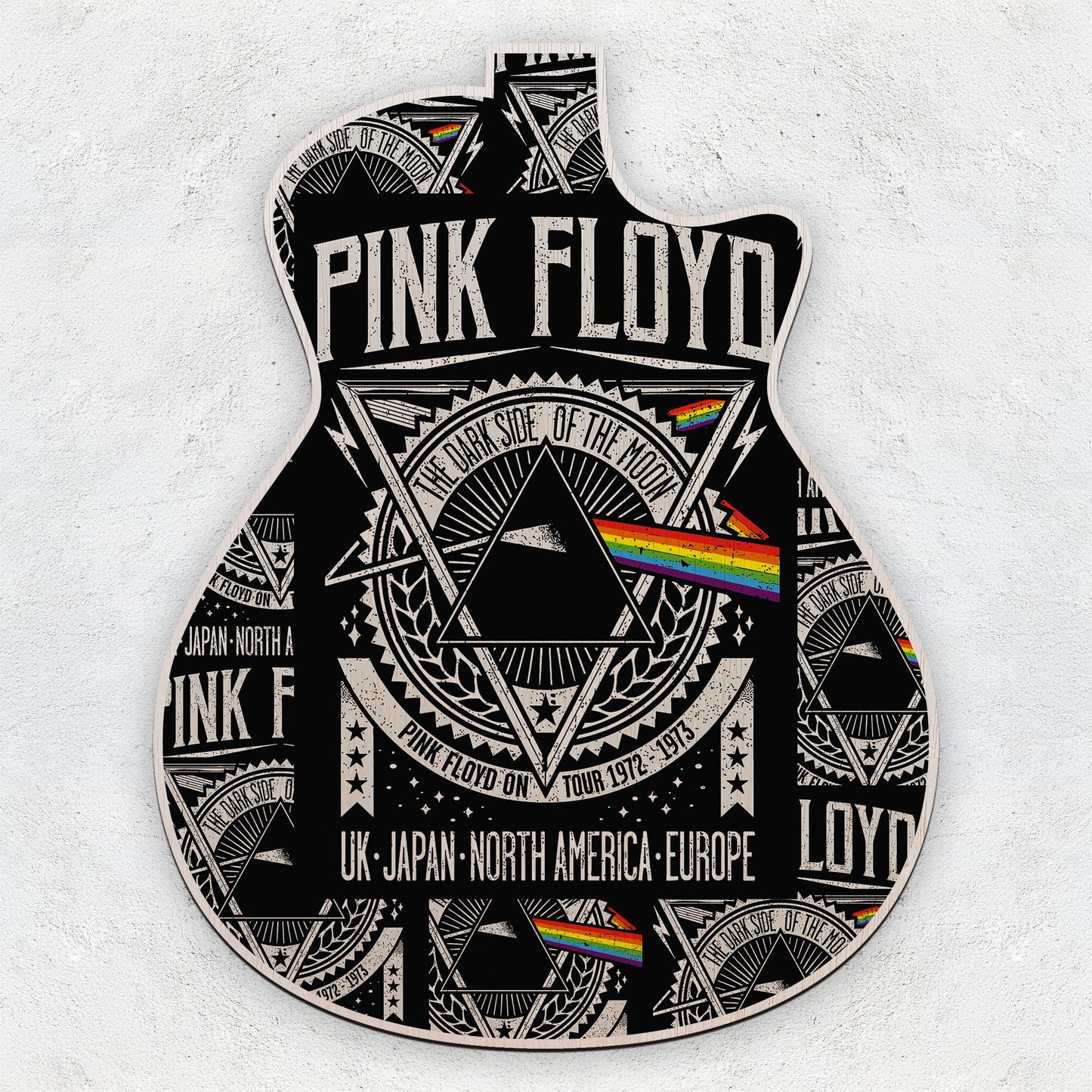 Decorative guitar pick with Pink Floyd design on a white background
